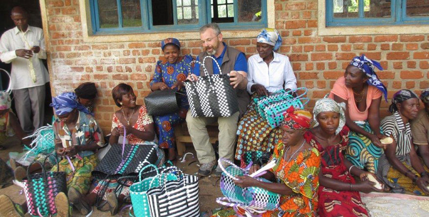 Thomas Becker mit afrikanischen Frauen, die Körbe herstellen