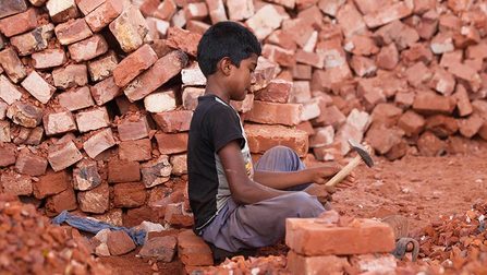 Ein kleiner Junge arbeitet in einem Ziegelsteinbruch.
